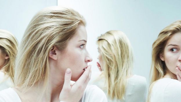 Chica preocupada mirándose al espejo