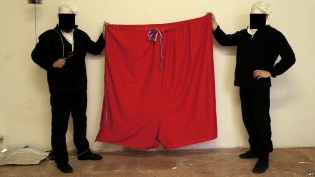 Two members of a Czech art group hold up a huge pair of red underpants