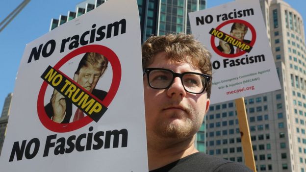 Mike Vultaggio, of Warren, is amongst the protesters voicing their opinion against Republican presidential candidate Donald Trump, as he speaks inside at the Detroit Economic Club at the Cobo Center in downtown Detroit, Monday, Aug. 8, 2016.