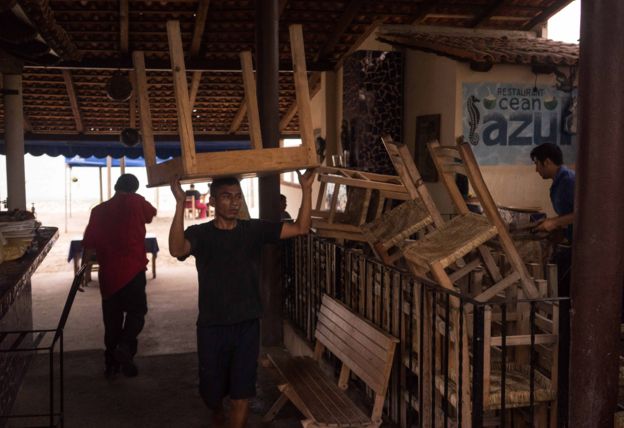 A worker carries a table at a seaside restaurant preparing for the arrival of hurricane Patricia in the Pacific resort city of Puerto Vallarta, Mexico, Thursday, Oct. 22, 2015