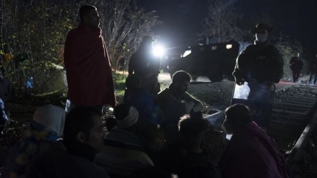 Macedonian police guard a group of migrants at the Macedonia-Greece border. Photo: 23 November 2015