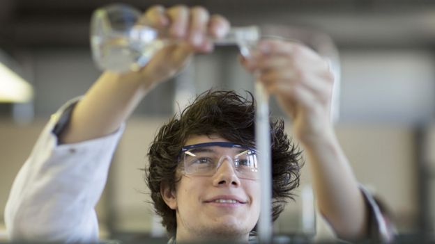 Adolescente haciendo un experimento en una clase de química