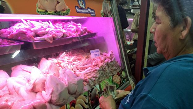 Venezolana compra patas de pollo.