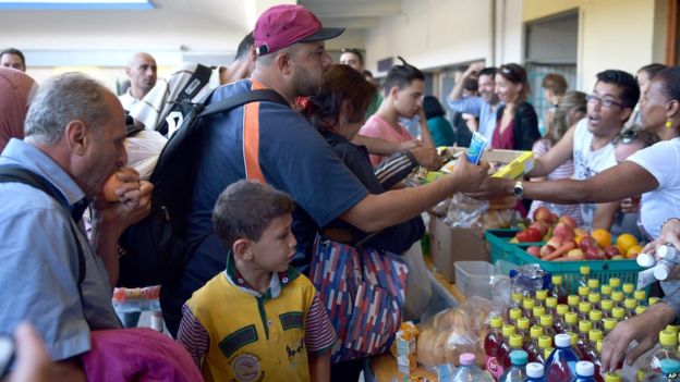People receive food after they arrived at a railway station in Vienna, Austria, on Tuesday, Sept. 1, 2015.