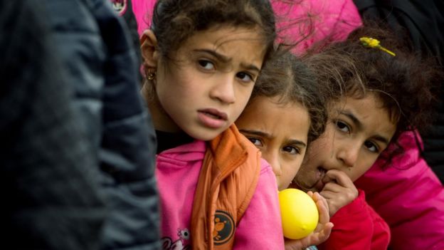 Children queuing for food distributed at a makeshift camp occupied by migrants and refugees at the Greek-Macedonian border on 2 March 2016