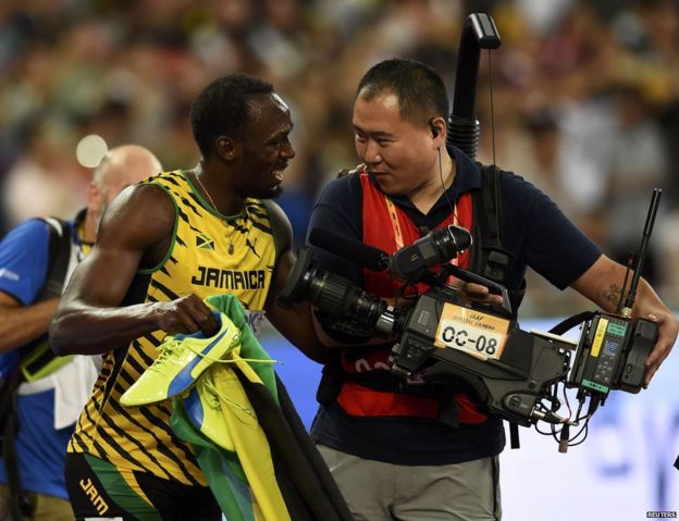 Usain Bolt of Jamaica chats with a cameraman after winning the men