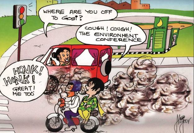 Comic showing Gogi on a motorcycle, speaking to a woman driving a van beside her which is emitting lots of fumes. The woman asks: