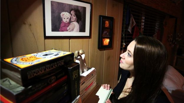Casey Anthony en su casa mirando un retrato de ella con su hija.