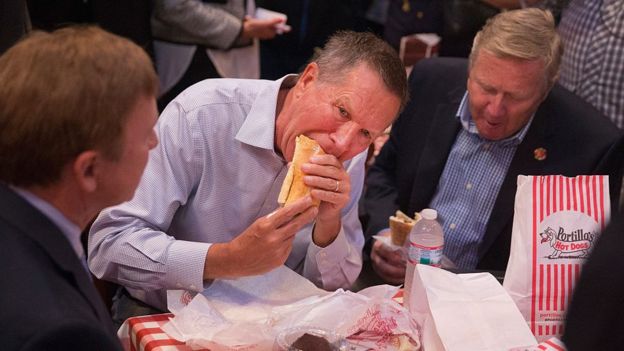 John Kasich eats a sandwich in Chicago.