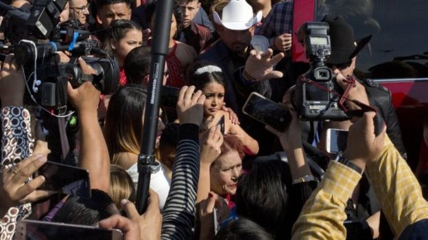 Rubi Ibarra arrives at the site of a Mass that is part of her down-home 15th birthday party, surrounded by a horde of journalists, in the village of La Joya, San Luis Potosi State, Mexico, Monday, Dec. 26, 2016.