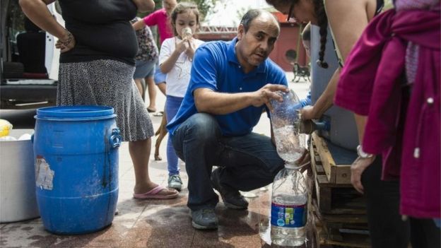 People get water during a drinking water supply cut in Santiago, on February 26, 2017.