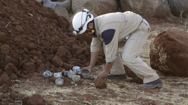 A civil defence member gathers unexploded cluster bombs that activists say were fired by the Russian planes at Maasran, southern Idlib province.