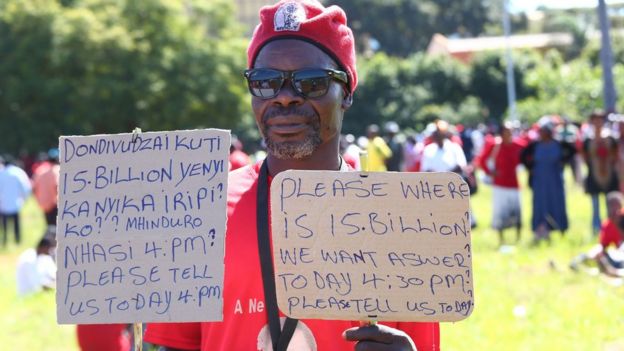 A supporter of the opposition party Movement for Democratic Change (MDC-T) holds placards during a protest against poverty and corruption, in Harare, Zimbabwe, 14 April 2016
