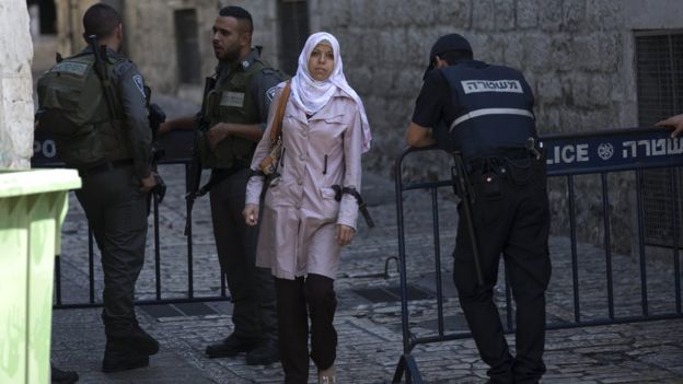 Palestinian women passing Israeli police on duty in the Old City of Jerusalem on 4 October 2015