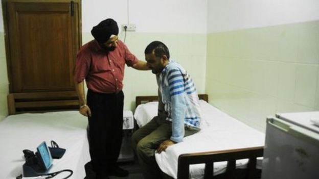 Terapeuta con un hombre joven sentado en una camilla