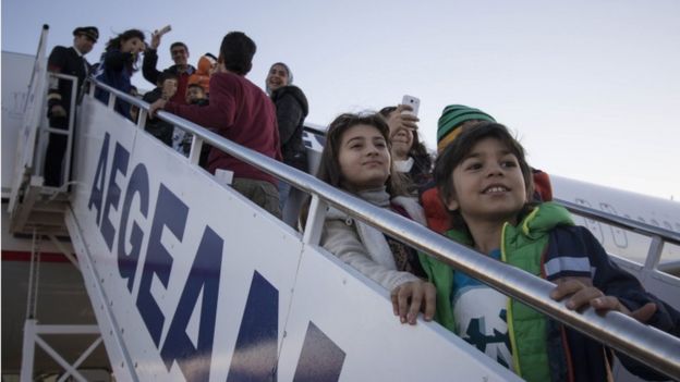 Refugees board an aircraft at Athens airport