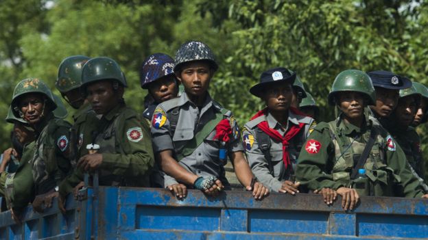Policías y militares birmanos en camiones llegan a una aldea de la minoría rohingya