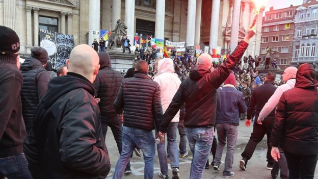Demonstrators disturb crowds at a makeshift memorial tribute to the victims of the Brussels terror attacks on Place de la Bourse square in Brussels 27/03/2016