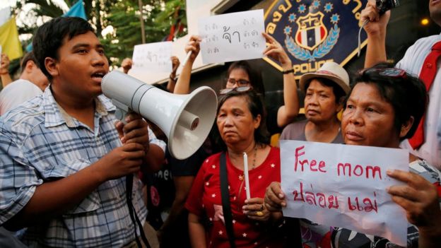 Anti-junta activist Sirawith Seritiwat, surrounded by supporters, holds a megaphone as part of a demonstration calling for the release of his mother