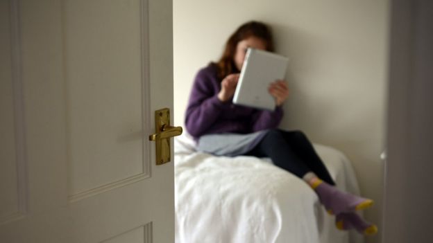 Niña con tableta en el dormitorio