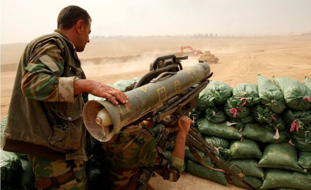 Um combatente curdo Peshmerga manipula um lançador de foguetes
