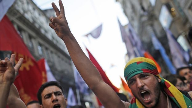 Protesters flash the V-sign as they chant slogans during a protest in Istanbul, Monday, July 20, 2015