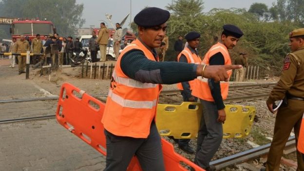 Members of the National Disaster Response Force (NDRF) direct operations near the crash site of a chartered army plane close to the main airport in New Delhi on December 22, 2015