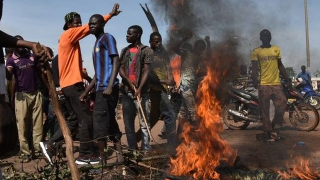 Demonstrators shout slogans next to burning tyres in Ouagadougou. Photo: 21 September 2015