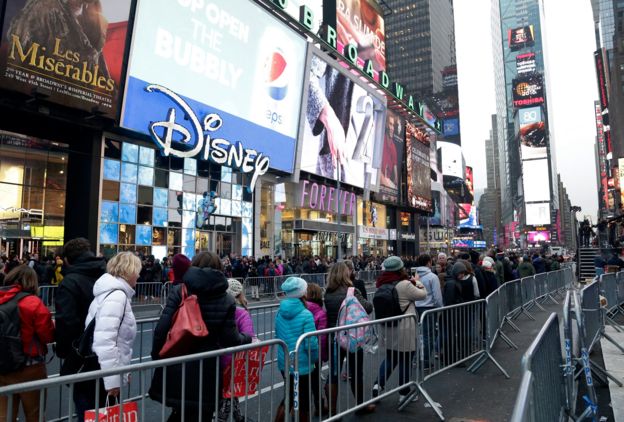 Pedestrians are seen walking past barricades in Times Square the day before New Year