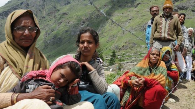Stranded pilgrims wait for their turn to be evacuated in an Indian Air Force helicopter at Badrinath on 29 June 2013
