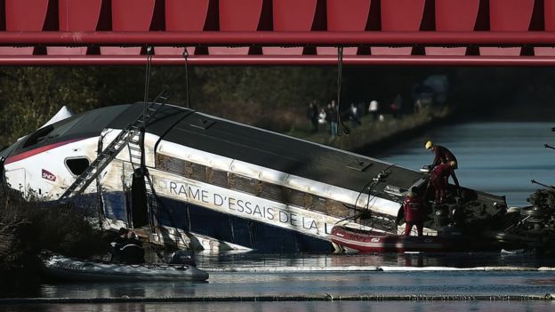 Workers at the wreckage of a derailed TGV train in France