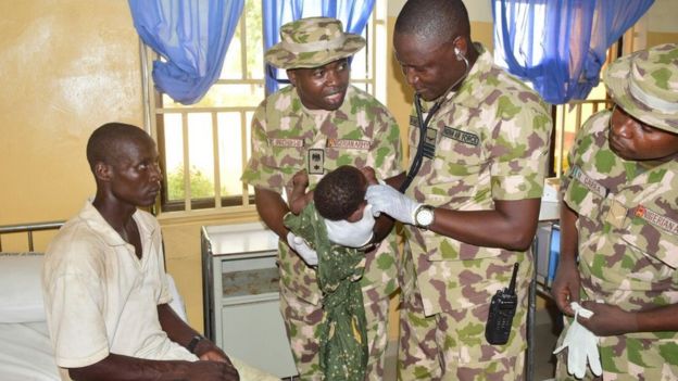 Army doctors examining a child