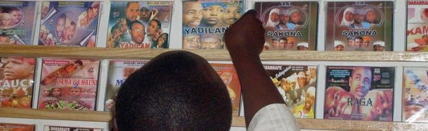 Man looking at Kannywood DVDs on a shelf