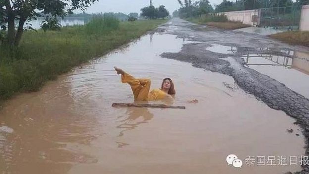 Woman posing in a pothole in Thailand