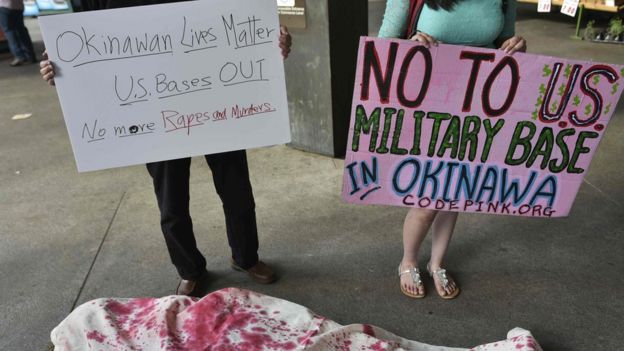 Activists, including some who are covered in mock shrounds, take part in a demonstration to protest against the US military presence in Okinawa, Japan