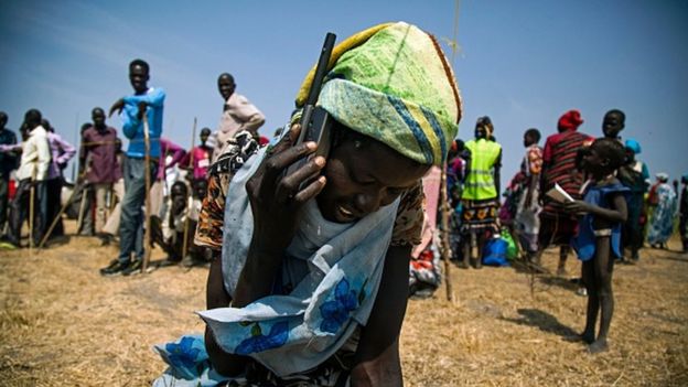 A South Sudanese woman uses a satellite phone provided by International Committee of the Red Cross on 3 February 2016 to call her lost relatives, who fled the village in October 2015