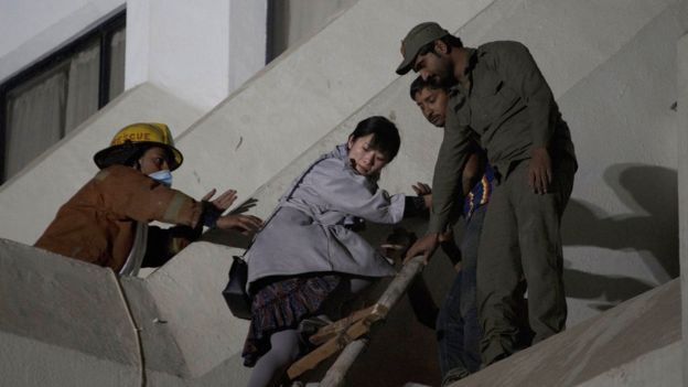 volunteers help a foreigner to escape following a fire at a hotel in Karachi, Pakistan, Monday, Dec. 5, 2016.