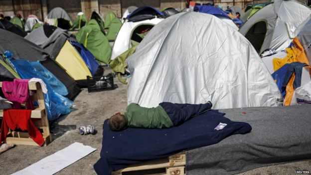 A child sleeps outside a tent in a makeshift migrant camp in Greece