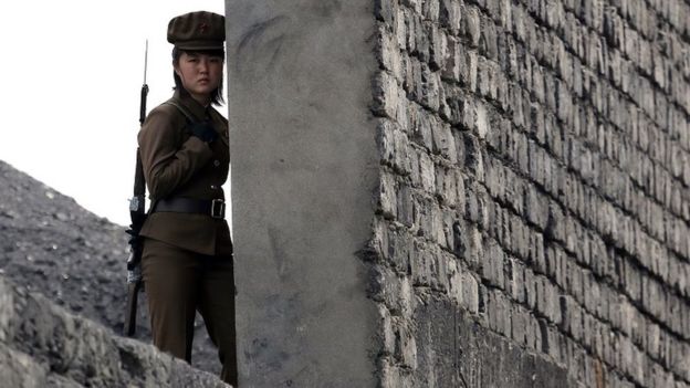 A North Korea woman soldier patrols the bank of the Yalu River which separates the North Korean town of Sinuiju from the Chinese border town of Dandong, northeast China's Liaoning province on April 26, 2014