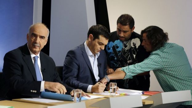 Alexis Tsipras, right, reads his notes next to New Democracy head Vangelis Meimarakis before a live televised debate at the state-run ERT television in Athens 9 September