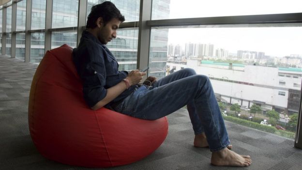 Ritesh Agarwal sitting on a beanbag by the window of the office