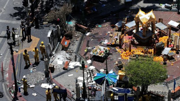 Thai police officers and emergency staff inspect the scene where Monday's bomb was detonated outside Erawan Shrine, central Bangkok, Thailand on Tuesday