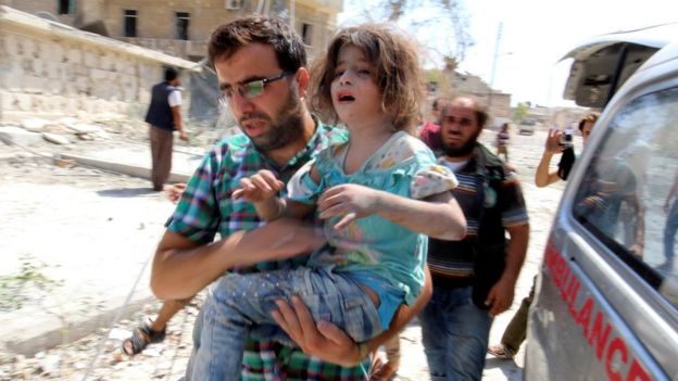A man carries a young girl after a reported barrel-bombing in Syria's Aleppo