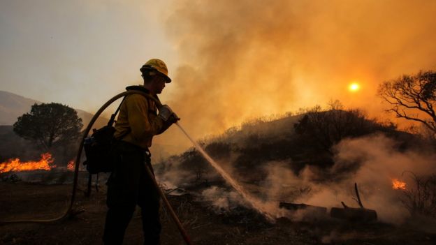 Un vigile del fuoco lavora per spegnere le fiamme a Santa Clarita in California la Domenica
