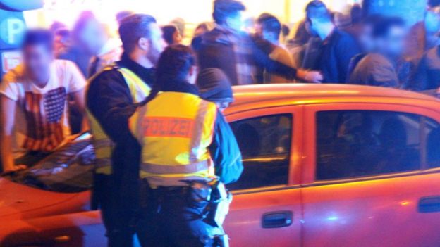 A man is led away by police officers at the main train station in Cologne, Germany (early 01 January 2016)