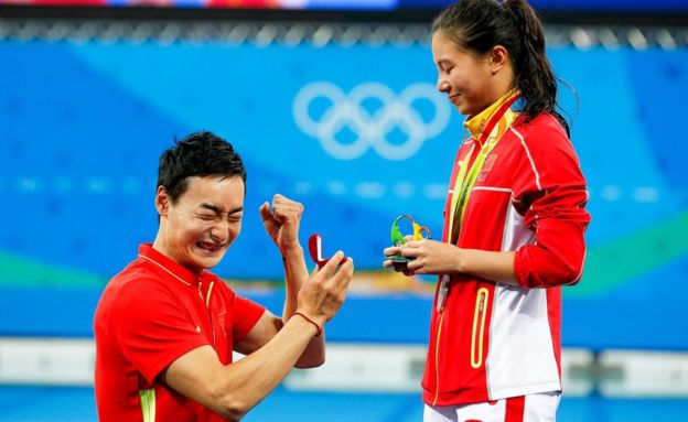 He Zi (R) of China receives a marriage proposal from Chinese diver Ki Qin (L) after winning the silver medal in the women