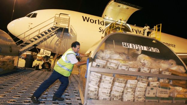 Un empleado cargo un avión de transporte de mercancías.