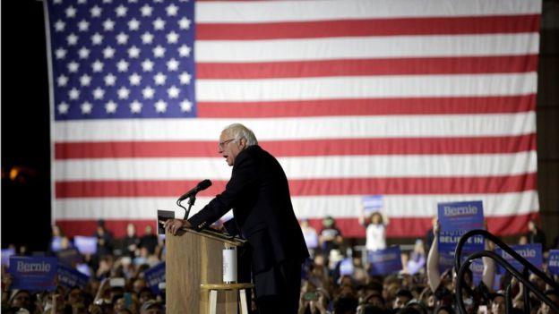 Picture of Bernie Sanders speaking to supporters in Santa Monica with a US flag in the background