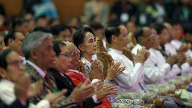 Aung San Suu Kyi claps alongside others after Myanmar's Commander-in-Chief Senior General Min Aung Hlaing speaks at the conference