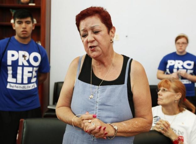 Norma McCorvey en una reunión con jóvenes con camisetas con las inscripciones